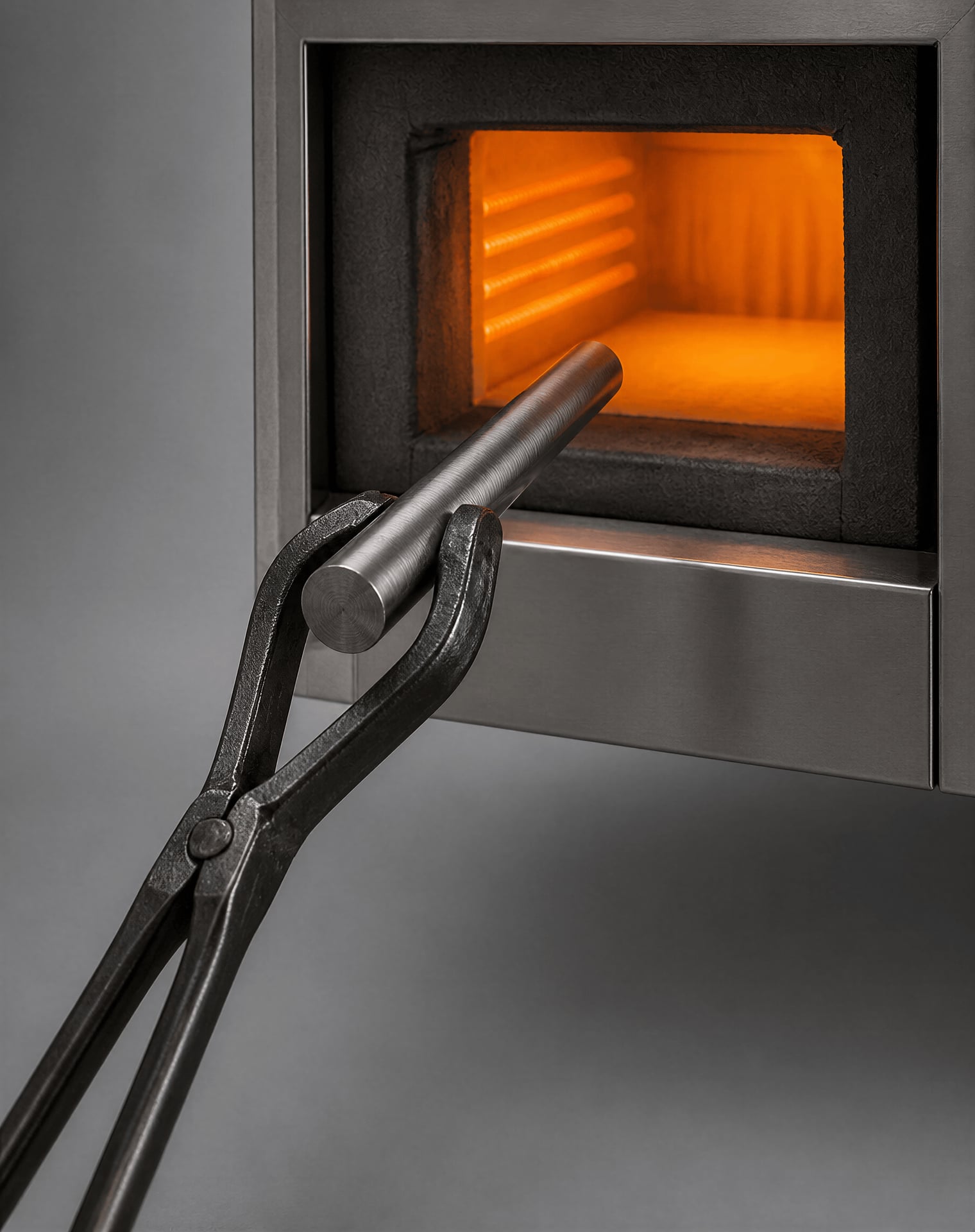 Cylindrical steel Jominy specimen being heated in a laboratory furnace