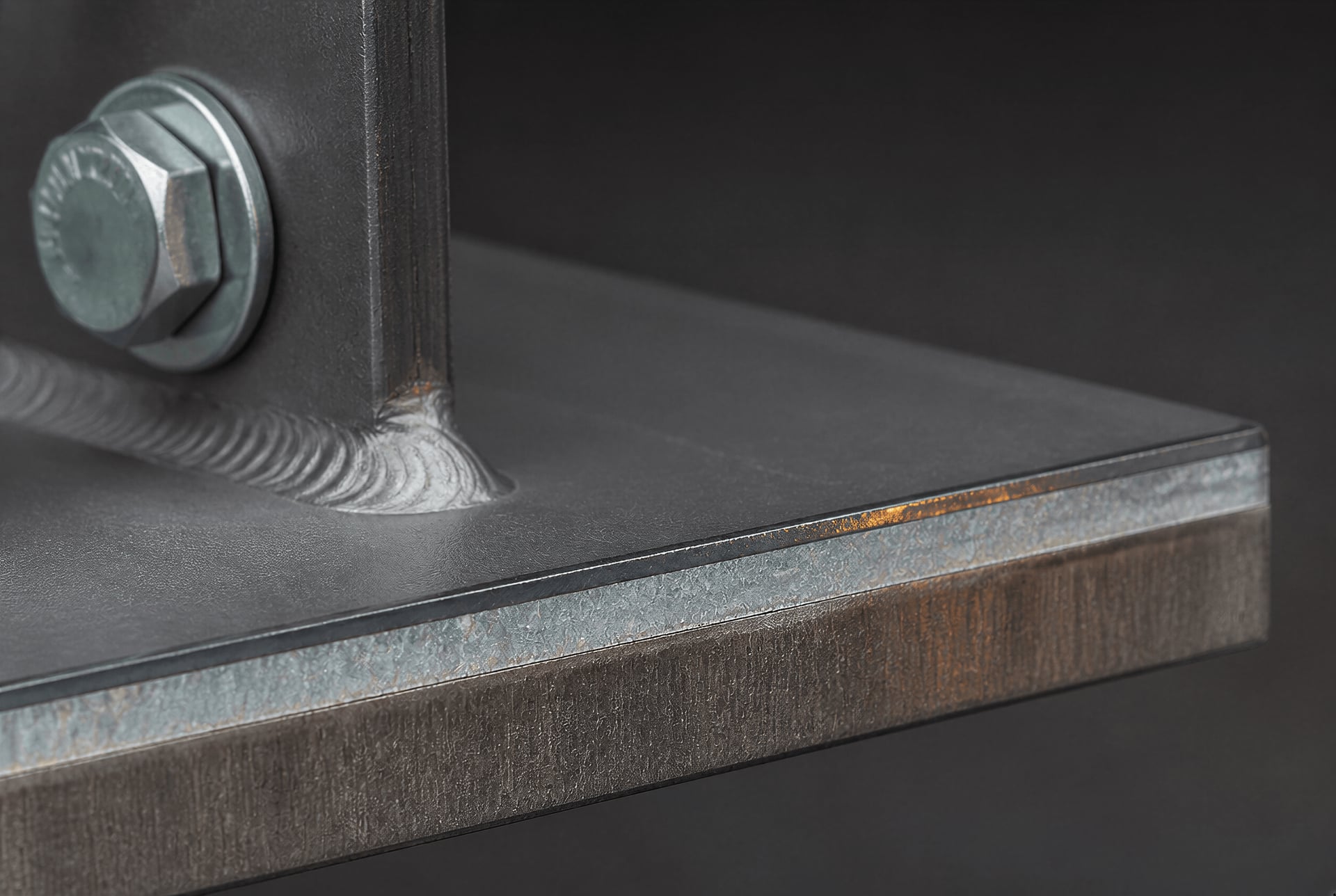 Macro view of coatings, a weld, and a bolted attachment on structural steel