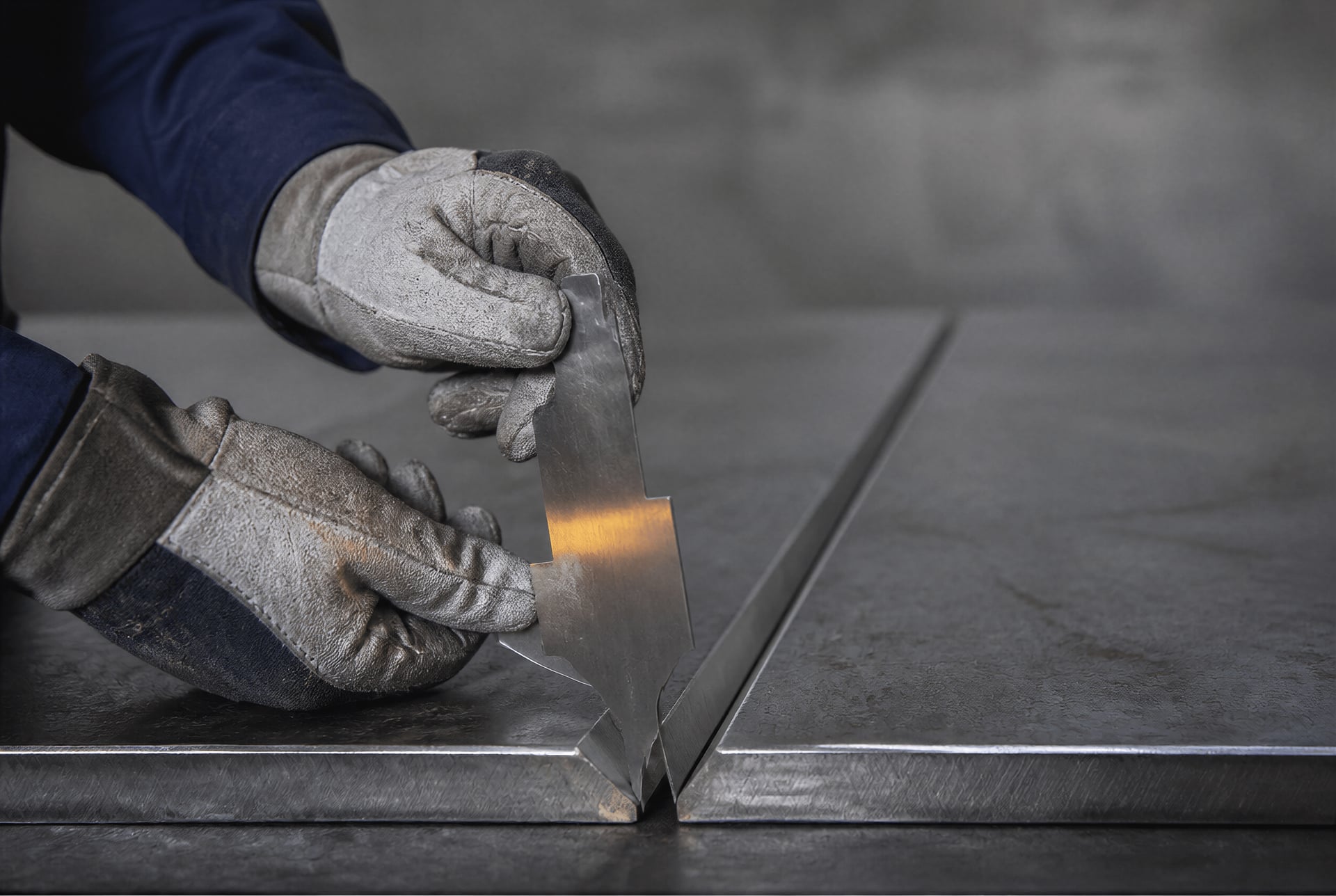 Inspector checking the root gap and alignment of a prepared steel joint before welding.